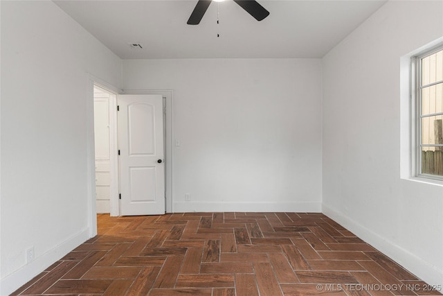 unfurnished room featuring ceiling fan and dark parquet floors