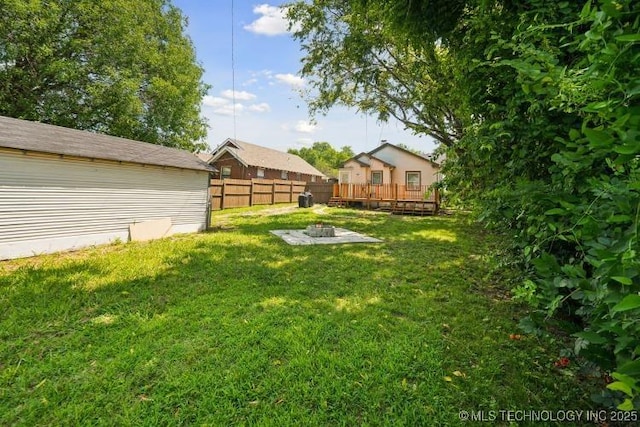 view of yard with a wooden deck and an outdoor fire pit