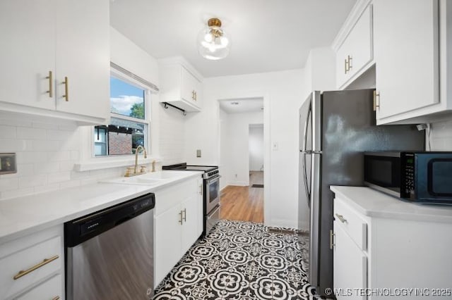 kitchen with tasteful backsplash, sink, white cabinets, light tile patterned floors, and stainless steel appliances