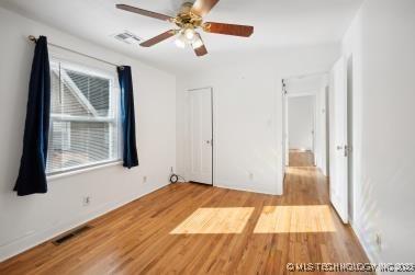 unfurnished bedroom with ceiling fan and light wood-type flooring