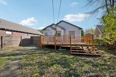 rear view of house featuring a yard and a deck