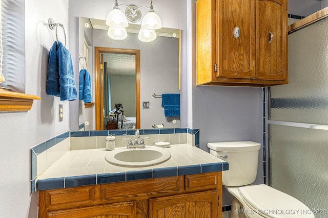 bathroom featuring vanity, toilet, and walk in shower