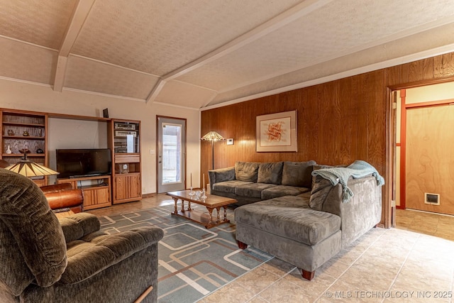 living room featuring wooden walls and lofted ceiling with beams