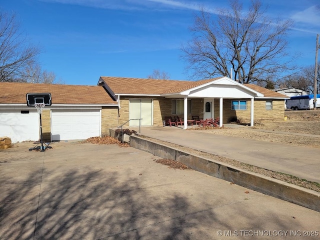 ranch-style home featuring a garage and covered porch