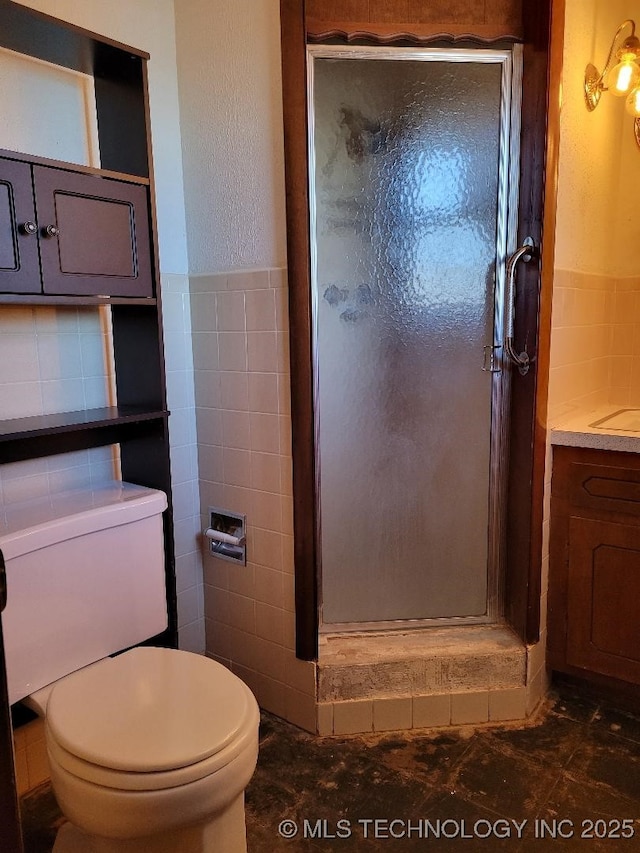 bathroom with vanity, toilet, an enclosed shower, and tile walls