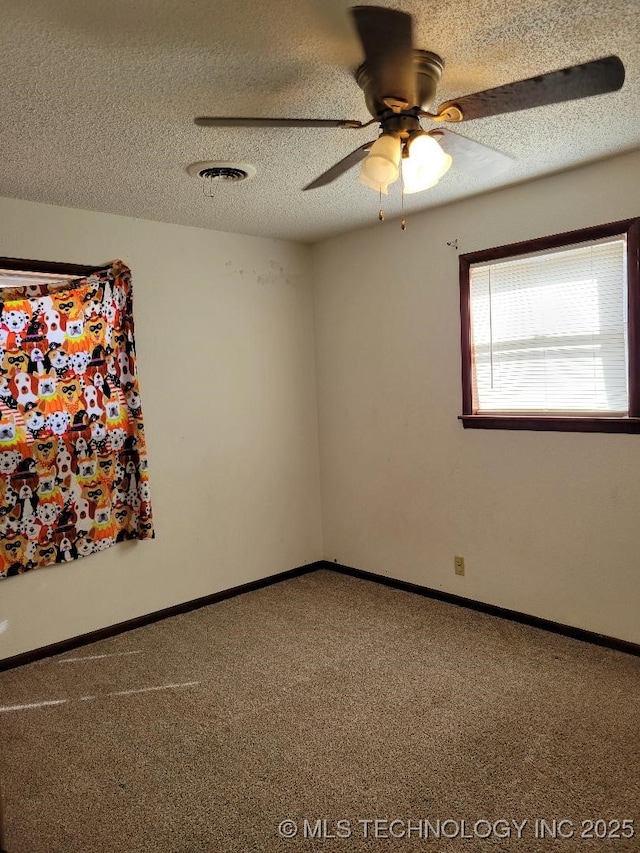 carpeted empty room featuring a textured ceiling