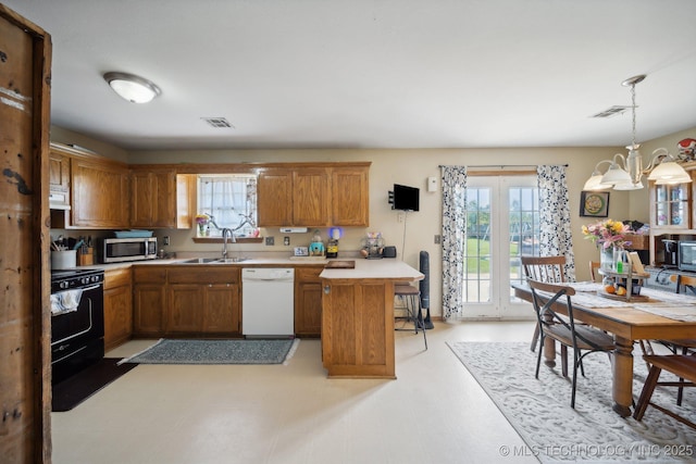 kitchen featuring pendant lighting, dishwasher, sink, a chandelier, and range