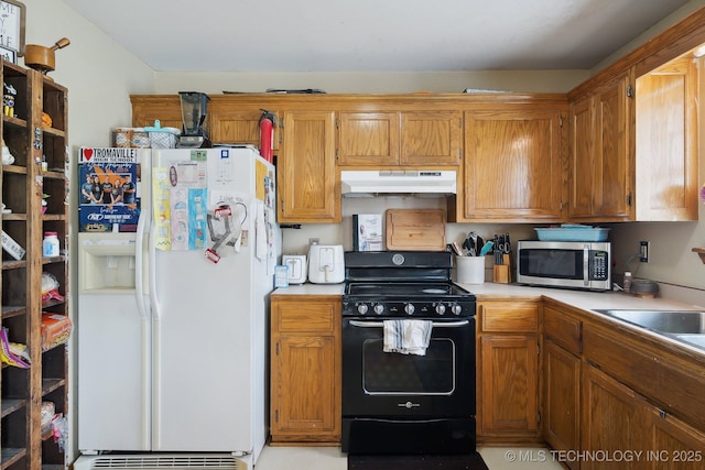 kitchen with white refrigerator with ice dispenser and black range