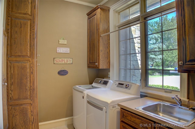 washroom featuring washer and dryer, sink, and cabinets