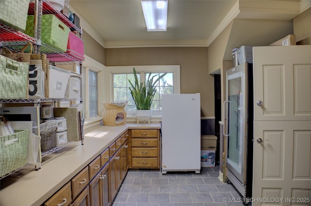 kitchen featuring crown molding and white refrigerator