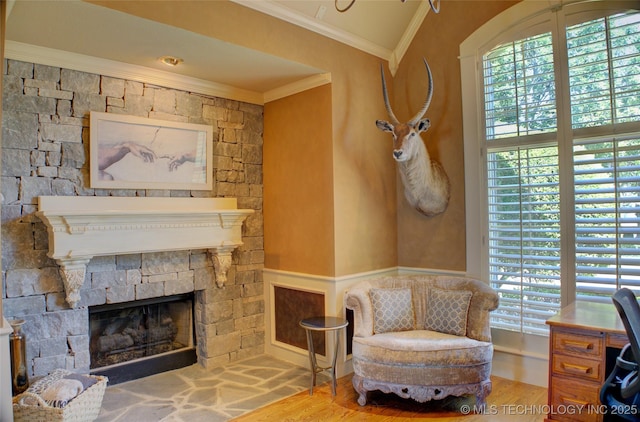 sitting room featuring ornamental molding, a healthy amount of sunlight, hardwood / wood-style floors, and a fireplace