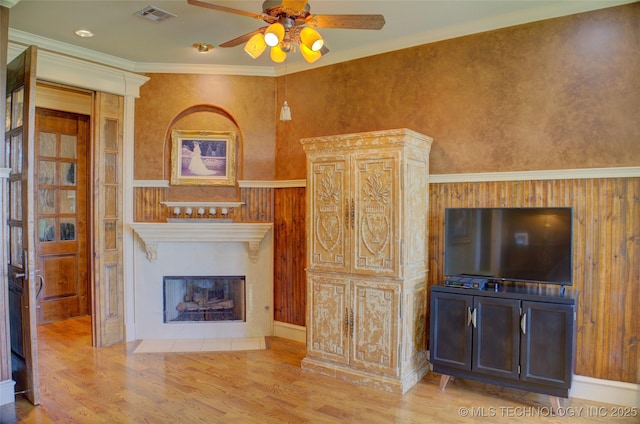 unfurnished living room featuring crown molding, ceiling fan, and light hardwood / wood-style flooring