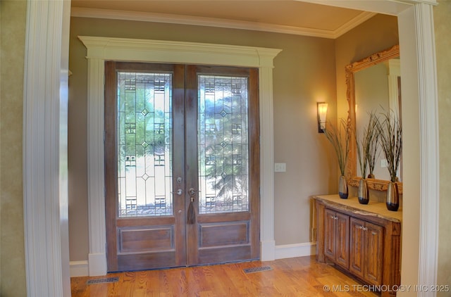 doorway with french doors, ornamental molding, and light hardwood / wood-style flooring