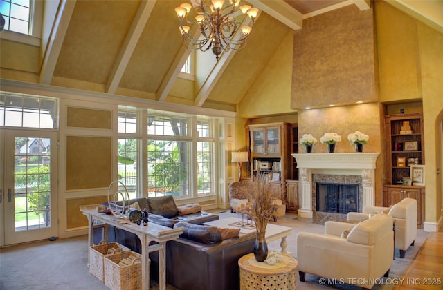 living room with built in features, beam ceiling, high vaulted ceiling, a high end fireplace, and a chandelier