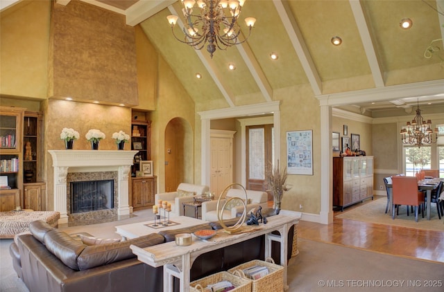 living room featuring beamed ceiling, a high end fireplace, high vaulted ceiling, and a notable chandelier