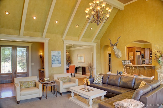 living room with high vaulted ceiling, ornamental molding, a notable chandelier, beam ceiling, and french doors