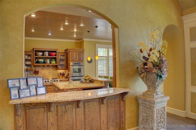 bar with sink, tasteful backsplash, ornamental molding, light stone countertops, and stainless steel double oven