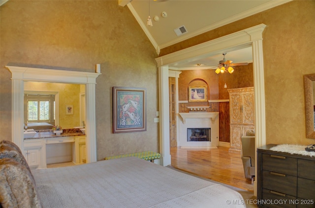 bedroom featuring high vaulted ceiling, built in desk, light hardwood / wood-style flooring, and ornamental molding