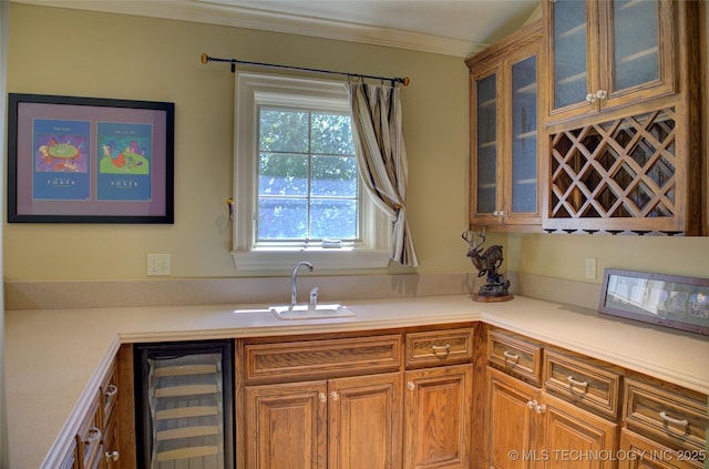 kitchen featuring ornamental molding, beverage cooler, and sink