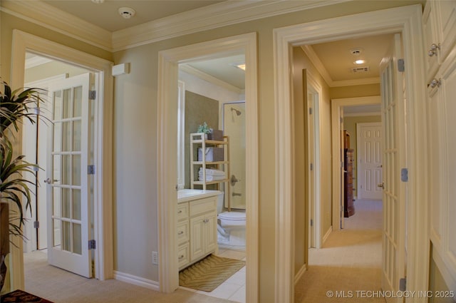 hallway featuring crown molding, light colored carpet, and french doors