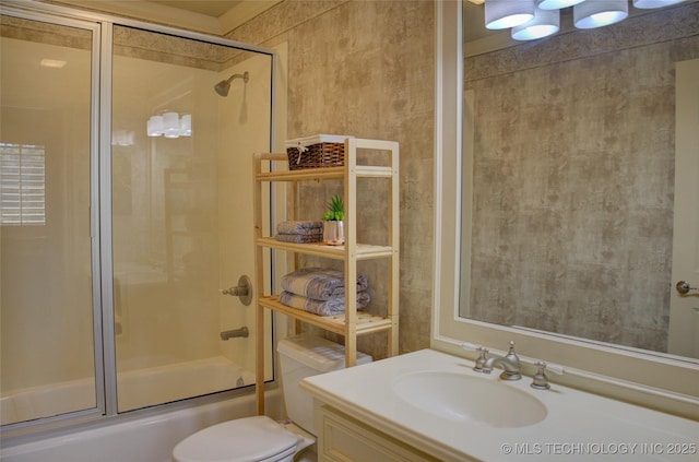 full bathroom featuring toilet, vanity, and shower / bath combination with glass door