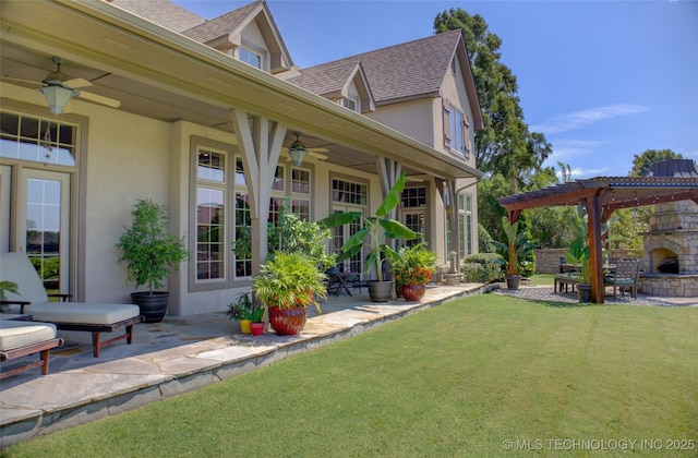 view of yard with a pergola, a patio area, and an outdoor stone fireplace