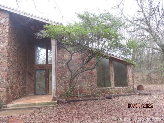 view of side of home with stone siding