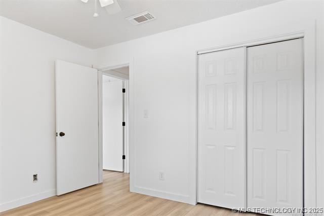 unfurnished bedroom with a closet, ceiling fan, and light hardwood / wood-style flooring