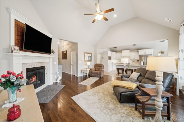 living room featuring ceiling fan, dark hardwood / wood-style floors, and high vaulted ceiling