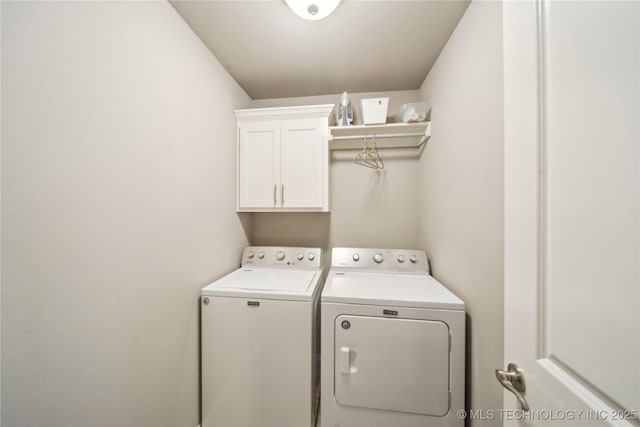 clothes washing area with cabinets and independent washer and dryer