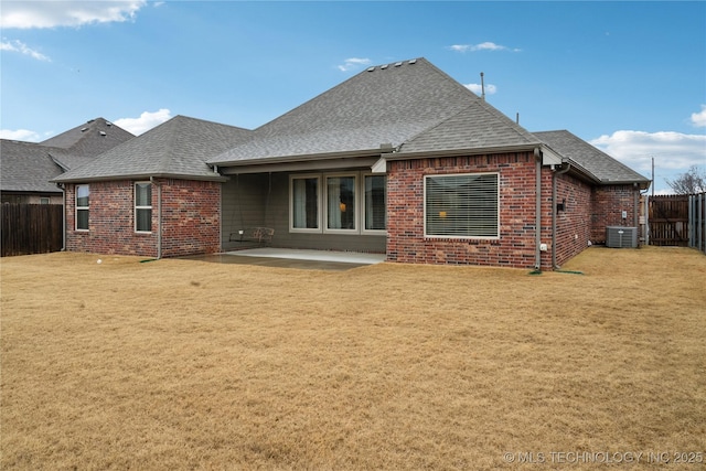 rear view of property featuring central AC unit, a patio area, and a lawn