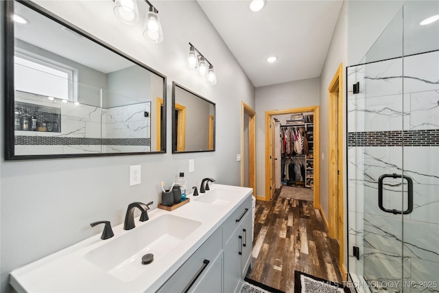 bathroom with hardwood / wood-style flooring, vanity, and a shower with door