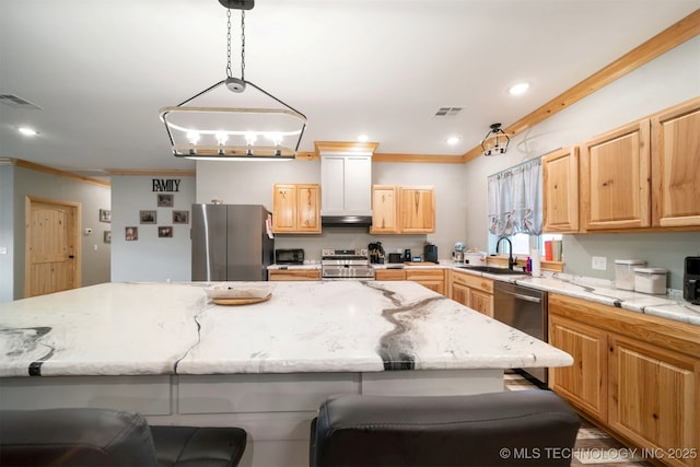 kitchen featuring a kitchen island, appliances with stainless steel finishes, pendant lighting, sink, and a breakfast bar area