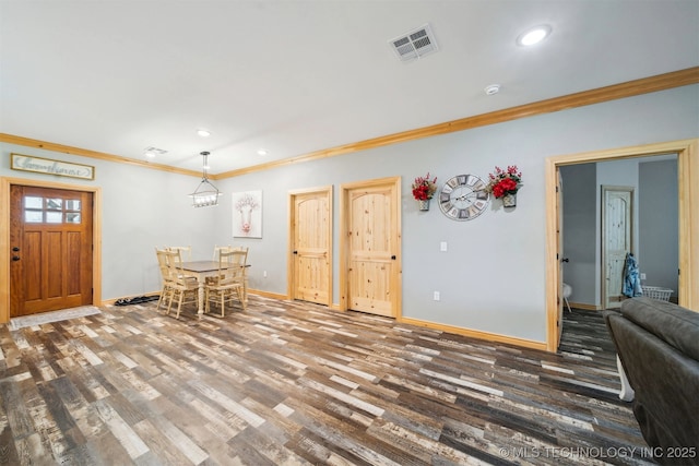 dining area with ornamental molding and dark wood-type flooring