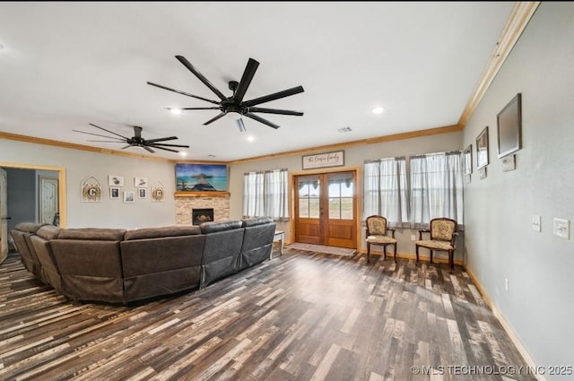 living room featuring dark wood-type flooring, a fireplace, french doors, and crown molding