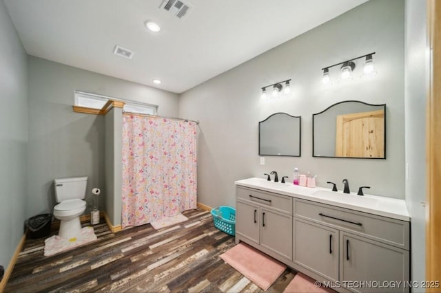 bathroom featuring wood-type flooring, toilet, curtained shower, and vanity