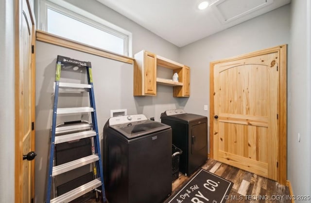 laundry room with separate washer and dryer, dark hardwood / wood-style flooring, and cabinets