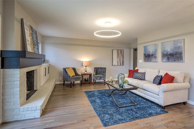 living room featuring hardwood / wood-style floors and a brick fireplace