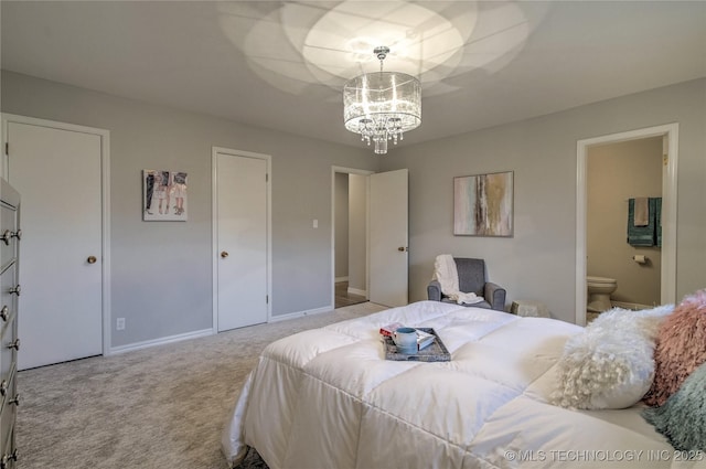 bedroom with ensuite bathroom, light carpet, and a notable chandelier