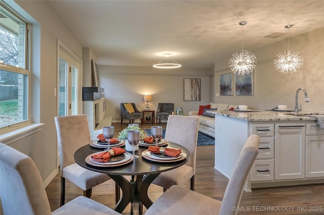 dining area featuring an inviting chandelier, dark hardwood / wood-style flooring, and sink