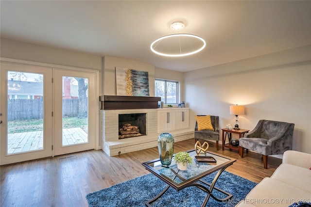 living room with a fireplace and light wood-type flooring