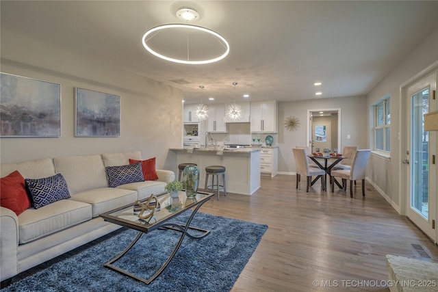 living room with sink and light hardwood / wood-style flooring