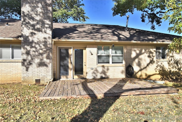 rear view of property featuring a lawn and a deck