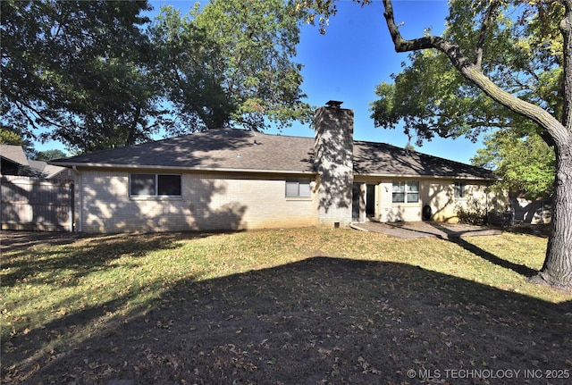 rear view of property with a lawn