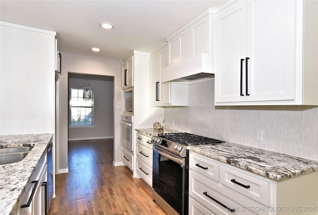 kitchen featuring white cabinetry, light hardwood / wood-style flooring, light stone countertops, and appliances with stainless steel finishes