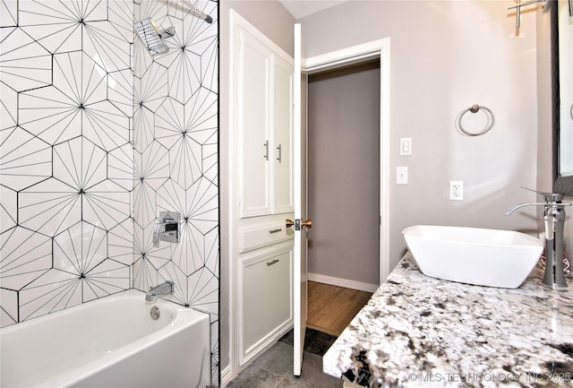 bathroom featuring tiled shower / bath and vanity