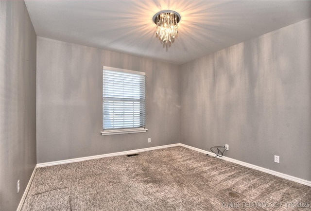 spare room with carpet floors and a notable chandelier