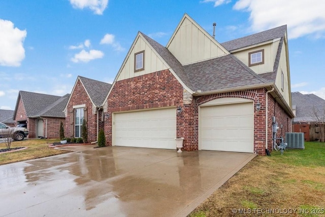 view of front of home with central AC, a garage, and a front yard