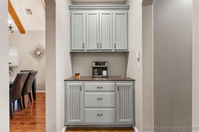 bar featuring gray cabinetry and hardwood / wood-style flooring