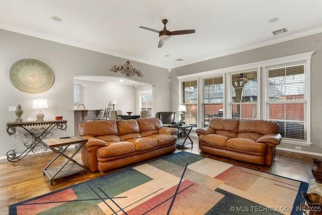 living room featuring hardwood / wood-style floors, crown molding, and ceiling fan